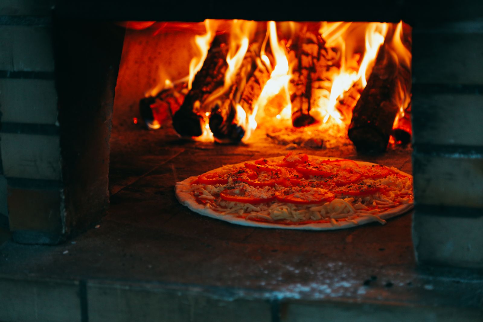 A pizza baking in the flames