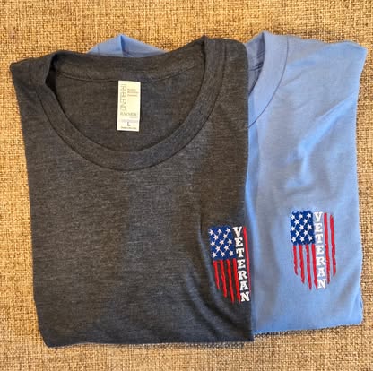 Two folded tees with an American-flag VETERAN design on the chest