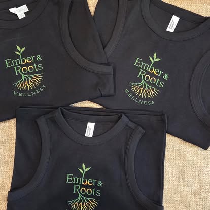 Black tanks embroidered with the Ember & Roots Wellness logo