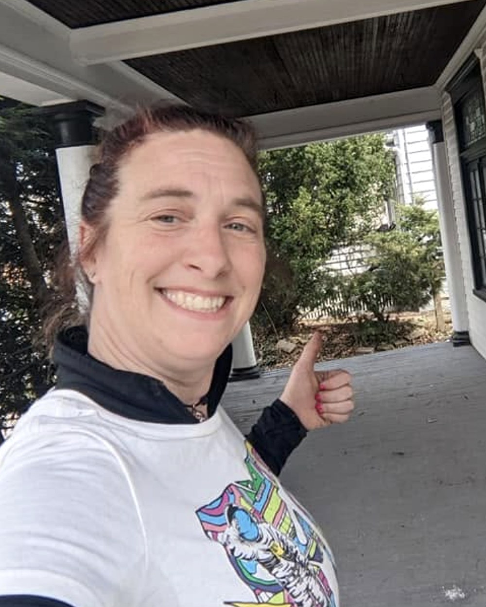 Mary smiling on a customer's porch, giving a thumbs up after a cleanout