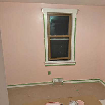 Primed and trimmed room mid-paint