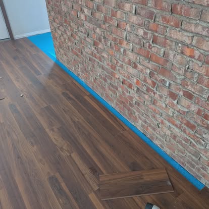 Dark LVP floor against brick with painter's tape
