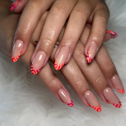 Almond nails with orange and red swirl French tips